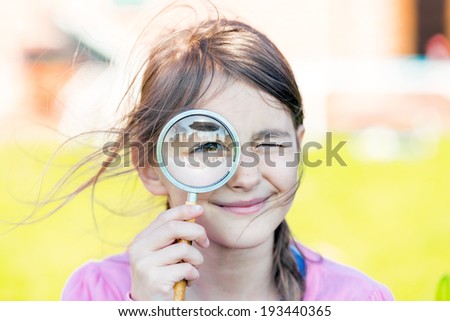 Little Girl looking through a magnifying glass