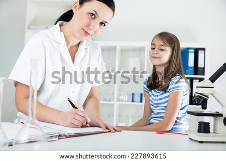 Young female doctor examining little cute child at  hospital .