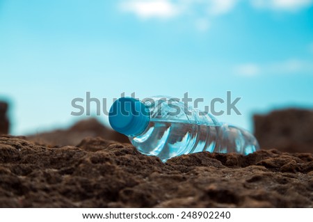 pet bottle with water on the sea sand.