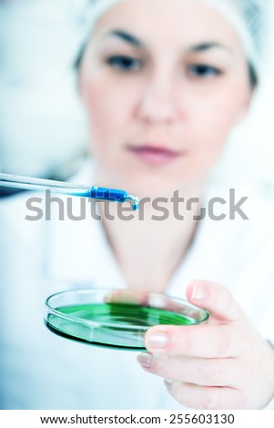 female researcher with glass equipment in the lab - soft focus on glass and hands