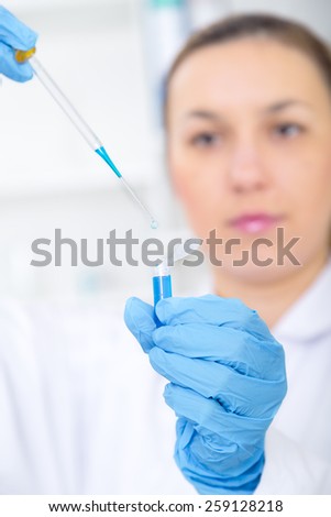 female researcher with glass equipment in the lab - soft focus on glass and hands