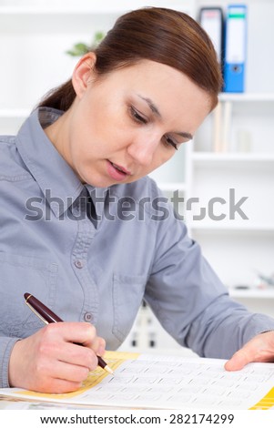 young business woman reading sitting at the desk on office background.