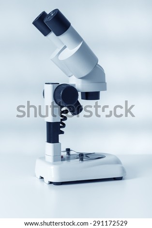 Scientific microscope lens on blue background, A microscope is an instrument used to see too small objects