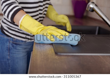 Hand with glove using cleaning  Kitchen at home.