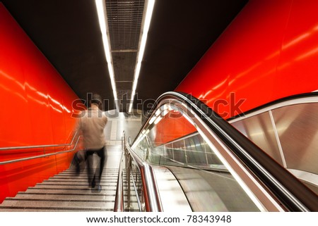 The escalator in motion. Motion blurred travellers.