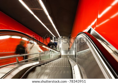 The escalator in motion. Motion blurred travellers.