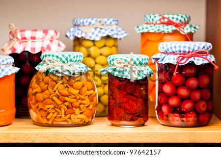 Preserved fruits and vegetables on the wooden shelf. Shallow deep of focus.