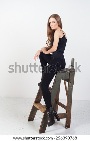 Glamour portrait of beautiful woman model with wooden ladder