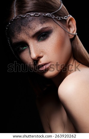 Fashion portrait of young woman with dark dusty make up and  head accessory of chains