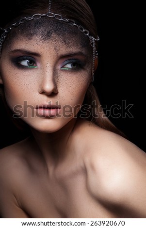 Fashion portrait of young woman with dark dusty make up and  head accessory of chains