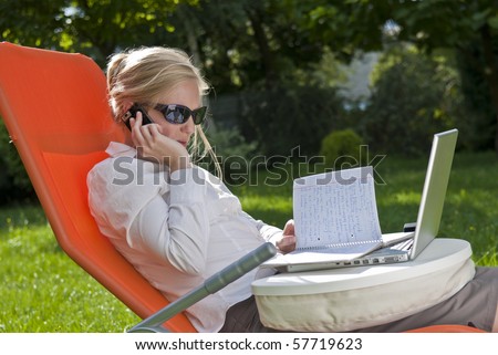 young woman working outside on computer, in the garden