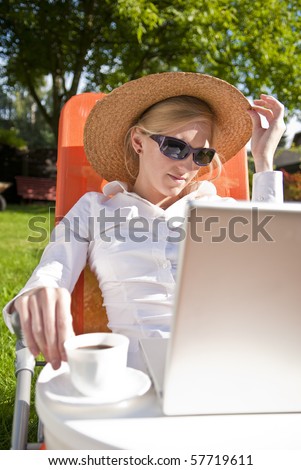 young woman working outside on computer, in the garden