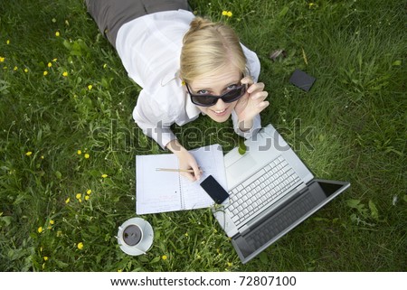 ypung woman working outside on computer