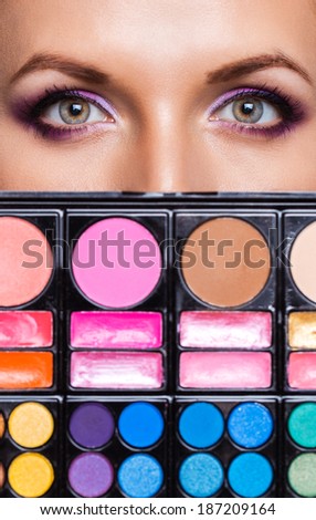 Closeup of beautiful womanish eyes with makeup kit and glamorous makeup