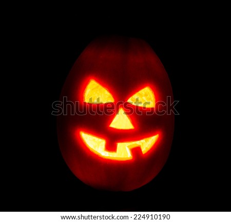 Halloween pumpkin jack-o-lantern candle lit, isolated on black background