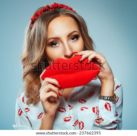 Pretty woman holding in hands big red lips, toy kiss-shaped, Valentine day concept