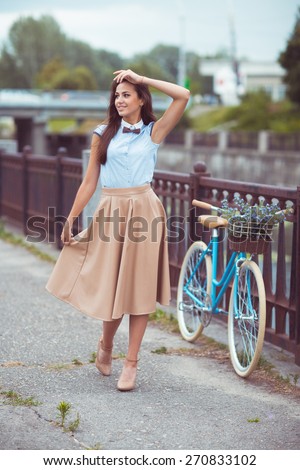 Young beautiful, elegantly dressed woman with bicycle. Beauty, fashion and lifestyle