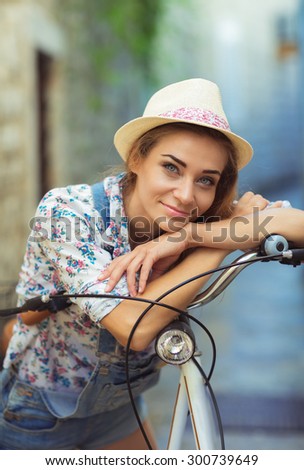 Beautiful happy woman with bicycle on street of old town