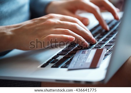 Hands using laptop and credit card on it. Online shopping