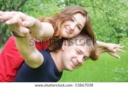 Young couple playing around in the nature - side view