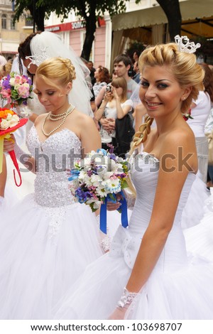 ODESSA, UKRAINE - MAY 27 : Annual event Bride Parade . Happy excited participants in fiancee`s gowns take part in celebration of marriage and romance Bride Parade on May 27, 2012 in Odessa, Ukraine