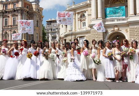 ODESSA, UKRAINE - MAY 26: Annual event Bride Parade. Happy excited participants in fiancee`s gowns take part in celebration of marriage and romance Bride Parade on May 26, 2013 in Odessa, Ukraine