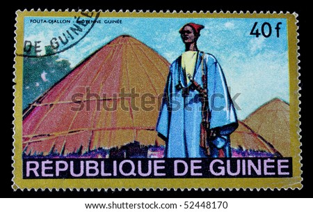 GUINEA - CIRCA 1968 : A post stamp printed in Republique de Guinee and shows man in national costume and his village. Circa 1968.
