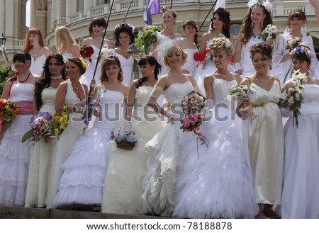 ODESSA,UKRAINE – MAY 29: Annual event “ Bride Parade”. Happy excited participants in fiancee’s gowns take part in celebration of marriage and romance Bride Parade on May 29, 2011 in Odessa,Ukraine