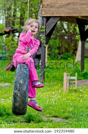 yung girl sitting in tire swing