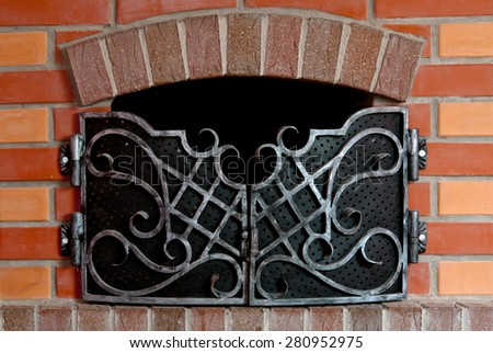 Close up of brick fireplace with an iron gate
