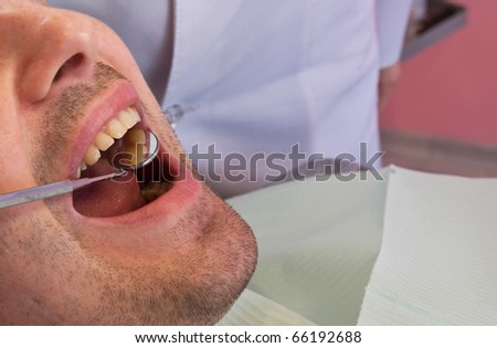 open mouth before oral inspection mirror near by
