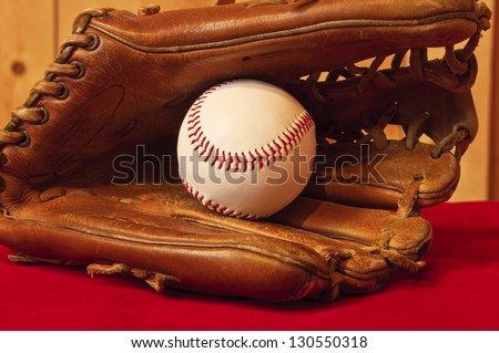 baseball and baseball glove on red background