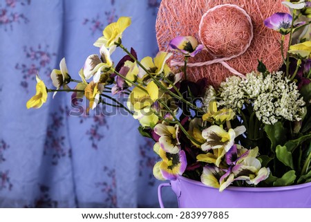 purple pale full of spring flowers and craft straw hat with vintage dress background