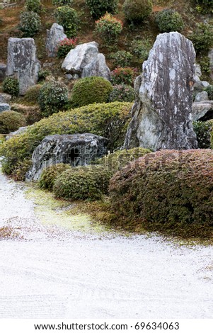 Zen garden raked gravel, vertical stone and azalea feature, Tofuku-ji Temple Garden, Kyoto, Japan.