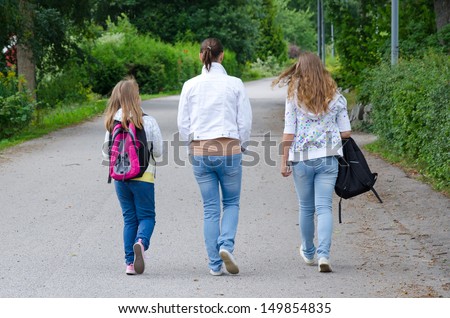 Girls with mother on the way back home from school