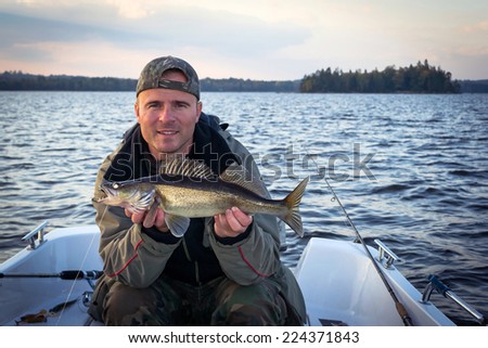 Happy angler with autumn walleye fish