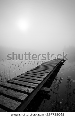 Wooden bridge in foggy scenery