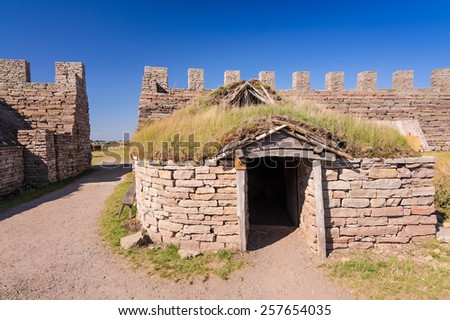 OLAND, SWEDEN - JUNE 21: Eketorp castle  - typical village hut, on Oland island on June 21,2014 in Sweden. Eketorp castle - built between 400-600AD and it\'s  tourist attraction on Oland island.