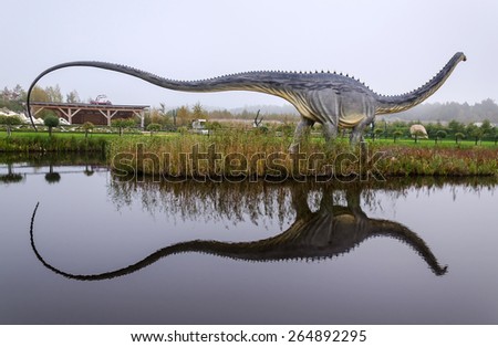 LEBA, POLAND- OCTOBER 01: Diplodocus dinosaur model with water reflection in open park in October 01, 2011, in Leba - Poland. Leba Park is 20ha area park in North Poland with original dinosaur models.
