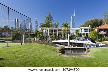 Waterfront backyard with tennis court and luxury yacht