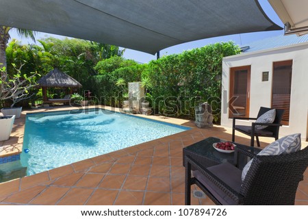 Modern backyard with swimming pool and Bali hut in Australian mansion