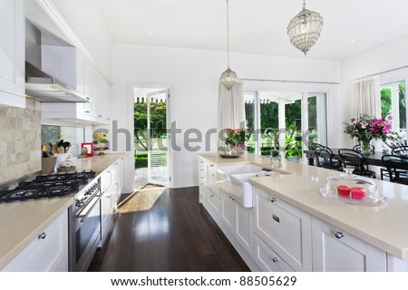 Stylish open plan kitchen with stainless steel appliances and dining area overlooking a pool and golf course