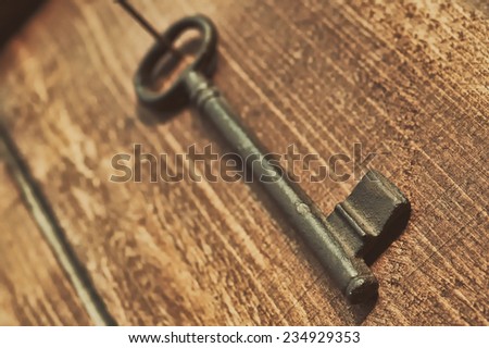 Vintage key on old wooden background