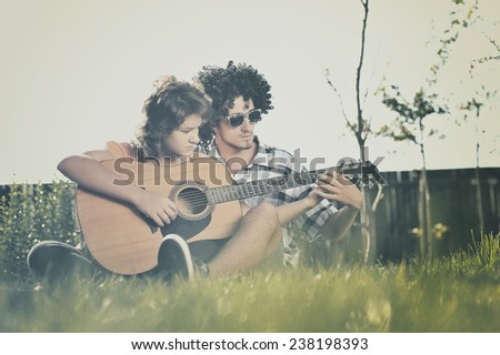 Boy teaches girl to play guitar