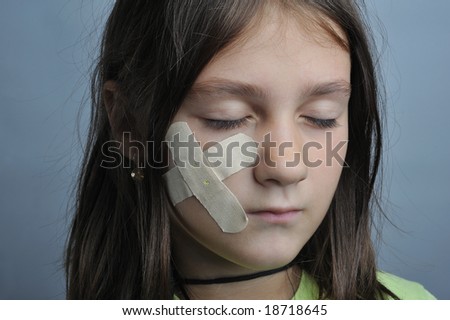 Little girl, close up portrait, with adhesive bandage on face