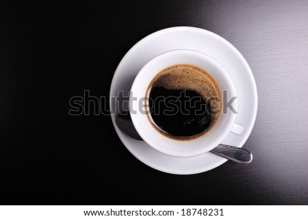Top view of a white cup of coffee on black background