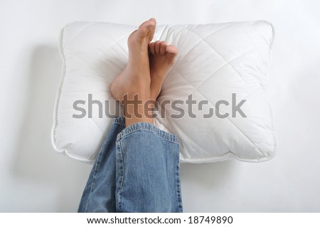 Foot resting on a white pillow, close up