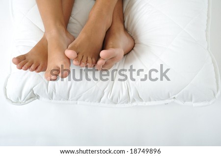 Foot resting on a white pillow, close up
