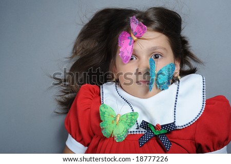 Close up portrait of a little girl with butterfly on face