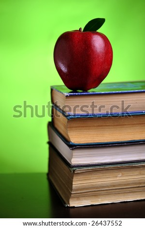 Stack of books with red apple, close up